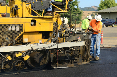 two man working with asphalt machine